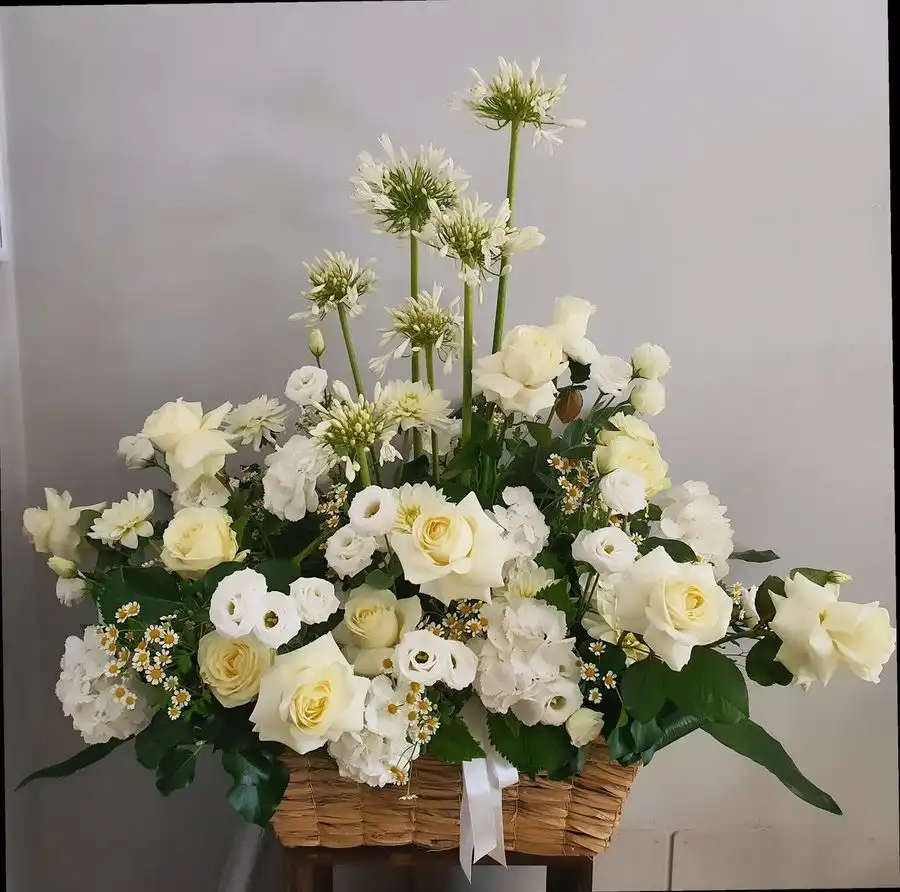Composizione di rose bianche, lisianthus e allium in un cesto