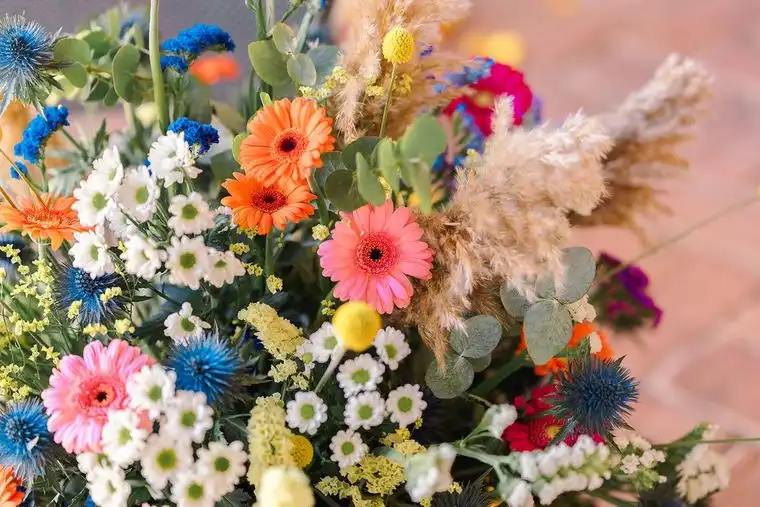 Allestimento di gerbere, margherite, fiordalisi e pampas